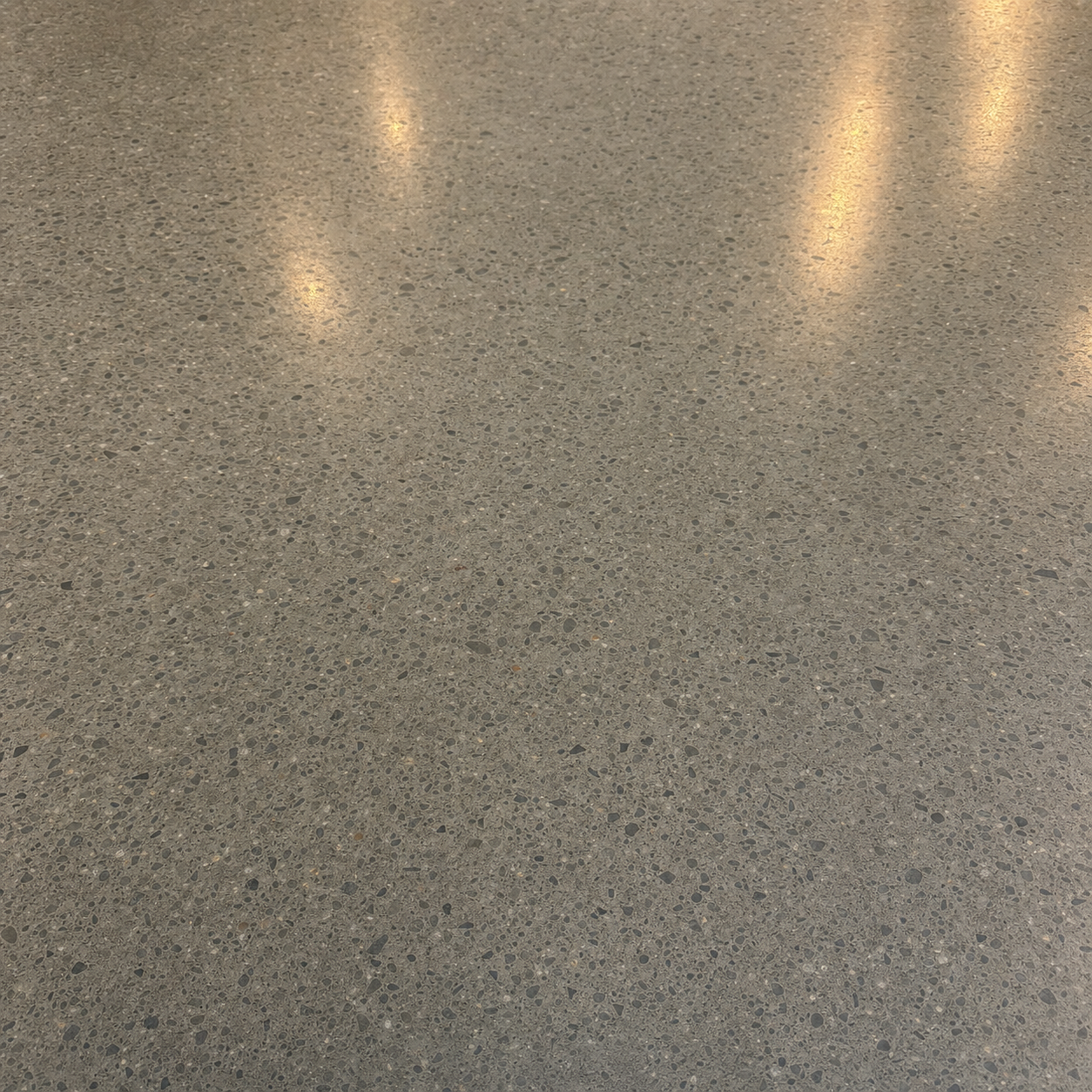 Polished concrete floor with mirror sheen and warm aggregate